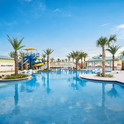 a large swimming pool with palm trees in a resort at Margaritaville Beach Cottage Resort Panama City Beach in Panama City Beach