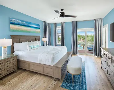 a bedroom with a large bed and a ceiling fan at Margaritaville Beach Cottage Resort Panama City Beach in Panama City Beach