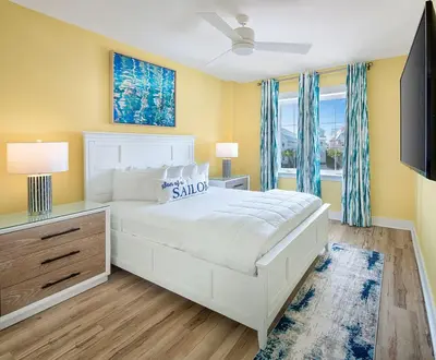 a white bedroom with a white bed and a window at Margaritaville Beach Cottage Resort Panama City Beach in Panama City Beach