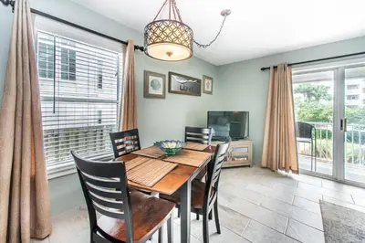 a dining room with a table and chairs and a television at Beachside Villas 814 in Santa Rosa Beach