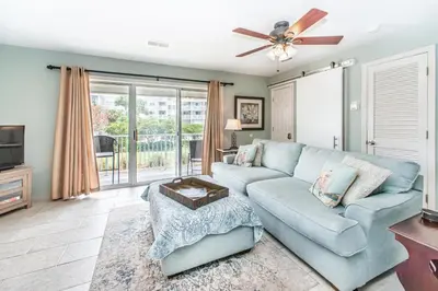 a living room with a blue couch and a tv at Beachside Villas 814 in Santa Rosa Beach