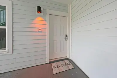 a door with a welcome sign on the side of a house at Beachside Villas 1123- A Sandy Carol in Santa Rosa Beach