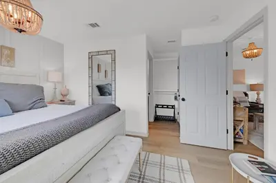 a white bedroom with a large bed and a table at Beachside Villas 1123- A Sandy Carol in Santa Rosa Beach