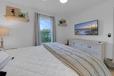 a white bedroom with a large bed and a window at Beachside Villas 1123- A Sandy Carol in Santa Rosa Beach