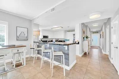 a kitchen and living room with a counter and chairs at Cassine Way 301 – 30A Blue Sky Breeze in Santa Rosa Beach