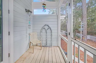 a porch with a chair and a window at Claire N' Bea by the Sea in Santa Rosa Beach