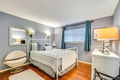 a bedroom with a bed and a chair and a window at Panama City Beach Condo with Pool and Beach Access! in Panama City Beach