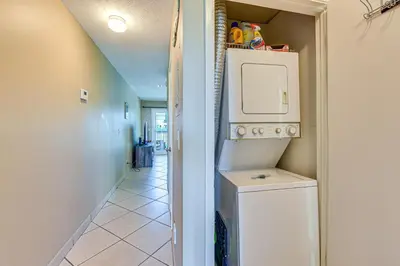 a hallway with a washer and dryer in a house at Panama City Beach Condo with Pool and Beach Access! in Panama City Beach