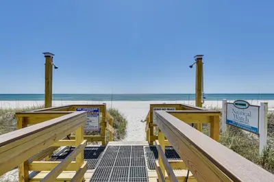 a walkway to the beach with a boardwalk at Panama City Beach Condo with Pool and Beach Access! in Panama City Beach