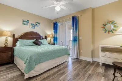 a bedroom with a bed and a ceiling fan at Casa Del Mar in Panama City Beach