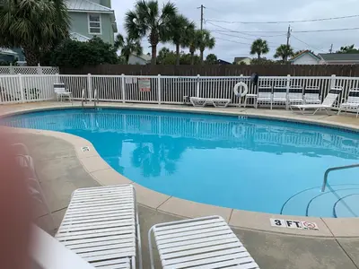 a large swimming pool with lounge chairs in a resort at Casa Del Mar in Panama City Beach