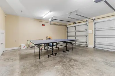 a ping pong table in a room with two garage doors at Casa Del Mar in Panama City Beach