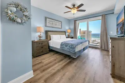 a bedroom with a bed and a large window at Laketown Wharf 827 - Lifes A Beach by Emerald Coast Retreats in Panama City Beach