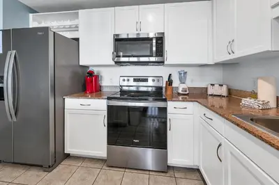 a kitchen with white cabinets and a stainless steel appliance at Laketown Wharf 827 - Lifes A Beach by Emerald Coast Retreats in Panama City Beach