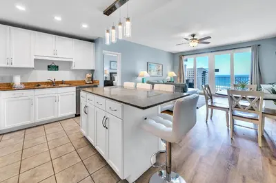 a kitchen with white cabinets and a table and chairs at Laketown Wharf 827 - Lifes A Beach by Emerald Coast Retreats in Panama City Beach