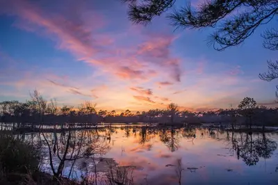 a sunset over a lake with a rainbow in the sky at Nautical Watch E-3 in Panama City Beach