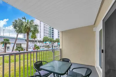 a balcony with chairs and a table with a view of the beach at Nautical Watch E-3 in Panama City Beach