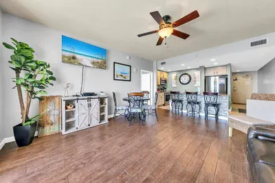 a living room with a ceiling fan and a dining room at Sterling Reef 1504 in Panama City Beach