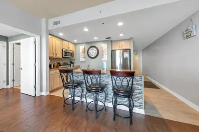 a kitchen with a counter with stools in it at Sterling Reef 1504 in Panama City Beach