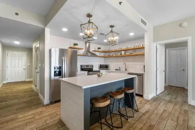 a kitchen with a large island with stools at Laketown Wharf #1411 by Nautical Properties in Panama City Beach