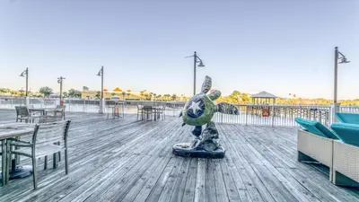 a statue on a boardwalk with tables and chairs at Laketown Wharf #1411 by Nautical Properties in Panama City Beach