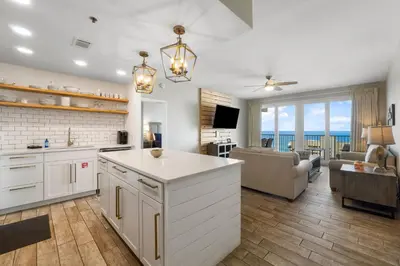 a kitchen and living room with a view of the ocean at Laketown Wharf #1411 by Nautical Properties in Panama City Beach
