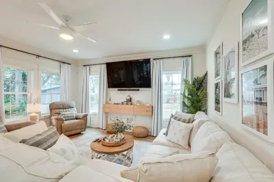 a living room with white furniture and a flat screen tv at Chic Panama City Beach Home, Walk to Laguna Beach! in Panama City Beach