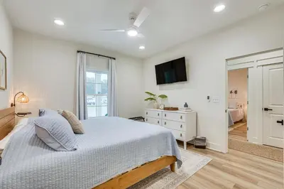 a bedroom with a bed and a tv on the wall at Chic Panama City Beach Home, Walk to Laguna Beach! in Panama City Beach