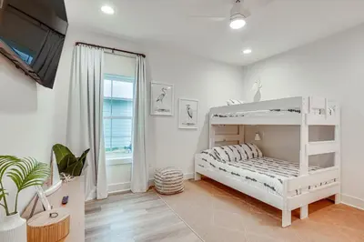 a bedroom with a white bunk bed and a window at Chic Panama City Beach Home, Walk to Laguna Beach! in Panama City Beach