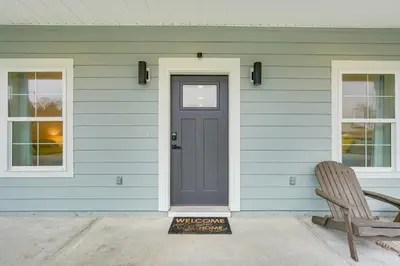 a blue house with a door and a bench at Chic Panama City Beach Home, Walk to Laguna Beach! in Panama City Beach