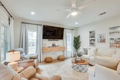 a living room with a couch and a tv at Chic Panama City Beach Home, Walk to Laguna Beach! in Panama City Beach