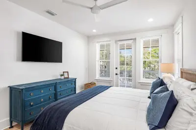a bedroom with a blue dresser and a tv on the wall at Southern Grove in Santa Rosa Beach