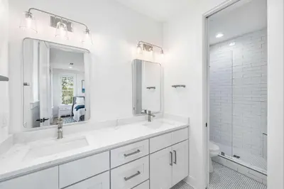 a white bathroom with two sinks and a mirror at Southern Grove in Santa Rosa Beach