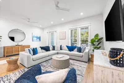 a living room with a gray couch and blue pillows at Southern Grove in Santa Rosa Beach