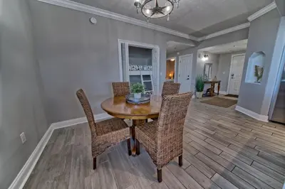 a dining room with a wooden table and chairs at Modern Oceanfront Retreat, Spacious Balcony - 0207 condo in Panama City Beach