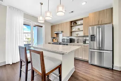 a kitchen with a stainless steel refrigerator and wooden cabinets at The Pointe 1-134 in Inlet Beach