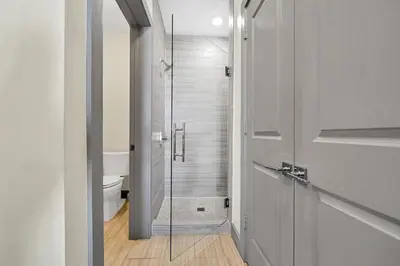 a bathroom with a toilet and a glass door at The Pointe 1-134 in Inlet Beach