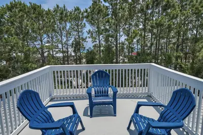three blue chairs on a deck with trees in the background at Hattie's Hideawy at Seacrest in Santa Rosa Beach