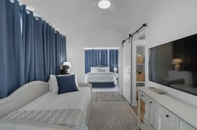 a bedroom with a large bed and a television at Hattie's Hideawy at Seacrest in Santa Rosa Beach