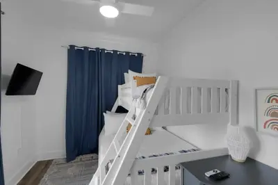 a white bunk bed with a ladder in a room at Hattie's Hideawy at Seacrest in Santa Rosa Beach