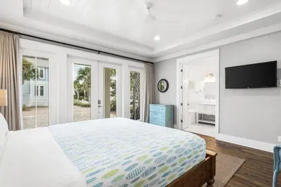 a bedroom with a large bed and a flat screen tv at Endless Summer Nights at Seacrest in Inlet Beach
