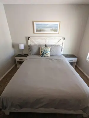 a bedroom with a large white bed with two night stands at PCB Haven - 2 Bedroom/1.5 Bath Condo in Gulf Highlands in Panama City Beach