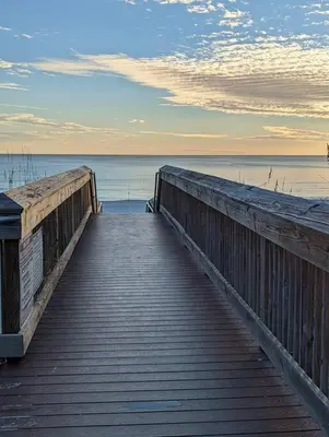 a wooden boardwalk leading to the water on a beach at PCB Haven - 2 Bedroom/1.5 Bath Condo in Gulf Highlands in Panama City Beach