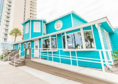 a blue house on the beach with condos at PCB Haven - 2 Bedroom/1.5 Bath Condo in Gulf Highlands in Panama City Beach