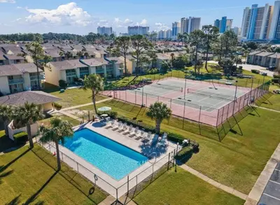 an aerial view of a pool and a tennis court at PCB Haven - 2 Bedroom/1.5 Bath Condo in Gulf Highlands in Panama City Beach