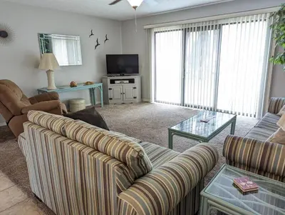 a living room with two couches and a television at PCB Haven - 2 Bedroom/1.5 Bath Condo in Gulf Highlands in Panama City Beach