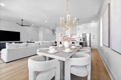 a dining room and living room with a table and chairs at Shimmy By The Sea by 30A Escapes in Panama City Beach