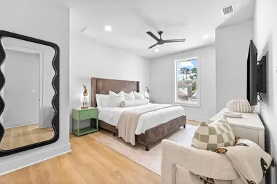 a bedroom with a large bed and a mirror at Shimmy By The Sea by 30A Escapes in Panama City Beach