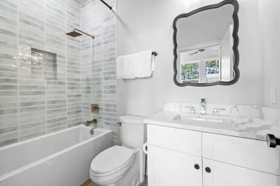 a bathroom with a toilet and a sink and a mirror at Shimmy By The Sea by 30A Escapes in Panama City Beach