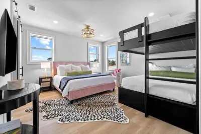 a bedroom with two bunk beds and a desk at Shimmy By The Sea by 30A Escapes in Panama City Beach